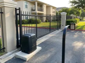 Slide gate, keypad and gate opener at the entrance of an apartment community