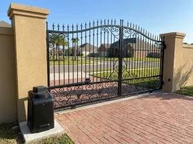 Gated entrance of a residential community with a gate opener beside the gate