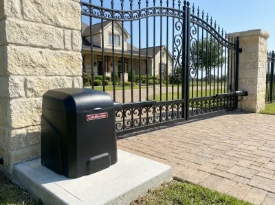Black LiftMaster gate opener on a concrete pad, its arm attached to a wrought-iron driveway gate