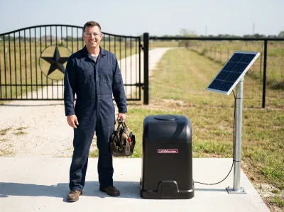 Gate mechanic with a tool bag beside a black LiftMaster gate opener and its solar panel, at a ranch gate